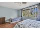 Bright bedroom with wood-look flooring, ceiling fan, and large window overlooking the outdoors at 7505 Pitch Pine Cir # 122, Tampa, FL 33617