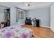 Bright bedroom with light walls, ceiling fan, wood floor, and window with view to the outside at 7505 Pitch Pine Cir # 122, Tampa, FL 33617