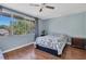 Cozy bedroom with wood floors, ceiling fan, and large window overlooking lush greenery at 7505 Pitch Pine Cir # 122, Tampa, FL 33617
