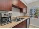 Kitchen with stainless sink and dishwasher, wood cabinets, neutral countertop and window view at 7505 Pitch Pine Cir # 122, Tampa, FL 33617
