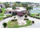 Aerial view showcasing a well-maintained property with lush landscaping, tennis courts, and a carport at 7701 Starkey Rd # 443, Seminole, FL 33777