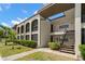 Exterior view of a two-story condo building featuring well-maintained landscaping and exterior staircases at 7701 Starkey Rd # 443, Seminole, FL 33777