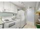 Functional kitchen with white appliances, tiled floor and ample storage space at 7701 Starkey Rd # 443, Seminole, FL 33777