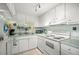 Well-lit kitchen features white cabinetry, neutral countertops, and appliances for a clean and functional cooking space at 7701 Starkey Rd # 443, Seminole, FL 33777