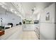Bright kitchen featuring white cabinets, countertops, and appliances, seamlessly connecting to the living area at 7701 Starkey Rd # 443, Seminole, FL 33777