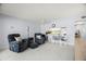 Bright living room featuring neutral paint, carpet, modern furniture, and a pass-through to the kitchen at 7701 Starkey Rd # 443, Seminole, FL 33777