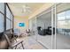 Enclosed condo patio with tile flooring, fan, and sliding glass doors leading to the spacious living room at 7701 Starkey Rd # 443, Seminole, FL 33777
