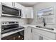 Close up view of new stainless steel appliances, white counters and subway tile backsplash in this newly updated kitchen at 8107 N 11Th St, Tampa, FL 33604