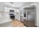 This kitchen features stainless steel appliances, white cabinets, subway tile backsplash and light wood flooring at 8107 N 11Th St, Tampa, FL 33604