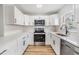 Bright kitchen featuring white cabinets, stainless steel appliances, light wood flooring, and white subway tile backsplash at 8107 N 11Th St, Tampa, FL 33604