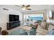 Living room with waterfront views, cozy seating, ceiling fan, and modern entertainment center at 865 S Gulfview Blvd # 308, Clearwater, FL 33767