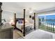Cozy main bedroom featuring a dark wood poster bed, area rug, and ocean view at 865 S Gulfview Blvd # 308, Clearwater, FL 33767