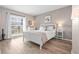 Inviting bedroom with white wooden bed frame, hardwood floors, and bright natural light from the window at 8703 Bardmoor Blvd # 305, Seminole, FL 33777