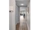 View of hallway with hardwood floors leading to the living room with natural light and patio access at 8703 Bardmoor Blvd # 305, Seminole, FL 33777