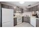 Functional kitchen features white appliances, grey cabinets, and a well-lit countertop space at 8703 Bardmoor Blvd # 305, Seminole, FL 33777