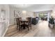 Open-concept living and dining area with hardwood floors, neutral walls, and balcony access at 8703 Bardmoor Blvd # 305, Seminole, FL 33777