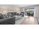 Comfortable living room featuring a plush sofa, balcony access, and light-filled space at 8703 Bardmoor Blvd # 305, Seminole, FL 33777