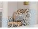 Patterned chair with accent pillow in a bright seating area at 8703 Bardmoor Blvd # 305, Seminole, FL 33777
