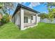 Well-manicured backyard with covered patio and lush green lawn at 8906 N Otis Ave, Tampa, FL 33604
