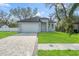 Beautiful single-story home with manicured lawn, paved driveway, and modern design at 8906 N Otis Ave, Tampa, FL 33604
