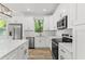 Modern kitchen featuring stainless steel appliances, white cabinetry, and stone countertops at 8906 N Otis Ave, Tampa, FL 33604