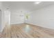 Open-concept living room with light wood floors, a modern chandelier, and natural light at 8906 N Otis Ave, Tampa, FL 33604