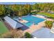 Aerial view of the community pool with a lifeguard station and lounge area surrounded by trees at 9503 W. Park Village Dr, Tampa, FL 33626