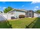 A spacious backyard featuring a screened-in patio, white fence, and lush landscaping at 9503 W. Park Village Dr, Tampa, FL 33626