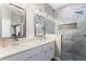 Well-lit bathroom featuring double sinks, quartz countertops, and stylish tiled walk-in shower at 9503 W. Park Village Dr, Tampa, FL 33626