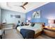 Primary bedroom with blue accent wall, dark wood furniture, exercise bike, and ceiling fan at 9503 W. Park Village Dr, Tampa, FL 33626