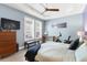 Bedroom with blue walls, wood furniture, tray ceiling and plantation shuttered windows at 9503 W. Park Village Dr, Tampa, FL 33626