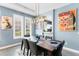 Dining room with a modern chandelier, shuttered windows, and seating for six at 9503 W. Park Village Dr, Tampa, FL 33626