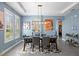 Dining room with a long modern table, modern art, bright windows, and seating for six at 9503 W. Park Village Dr, Tampa, FL 33626