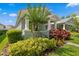 Exterior view of a home featuring manicured landscaping, including colorful foliage, and a welcoming porch at 9503 W. Park Village Dr, Tampa, FL 33626