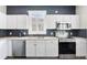 Kitchen area with stainless steel appliances, white cabinets, and gray tiled floor at 9503 W. Park Village Dr, Tampa, FL 33626