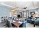 Open-concept living and dining area with blue furniture, modern lighting, and gray tile flooring at 9503 W. Park Village Dr, Tampa, FL 33626