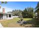 Spacious backyard with lush green lawn, mature landscaping, and charming three-tiered fountain feature at 1039 Union St, Clearwater, FL 33755