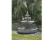 Beautiful tiered fountain in backyard setting with lush landscaping and a perched bird at 1039 Union St, Clearwater, FL 33755