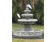 Three-tiered fountain surrounded by lush greenery, adorned with two white birds at 1039 Union St, Clearwater, FL 33755