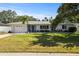 Charming single-story home with a well-manicured lawn, mature trees, and an attached garage at 1039 Union St, Clearwater, FL 33755