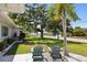 Home's front yard with green grass, palm tree and two chairs with a glimpse of the street and waterway beyond at 1039 Union St, Clearwater, FL 33755