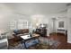 Cozy living room featuring a leather sofa, window shutters, hardwood floors, and access to the foyer area at 1039 Union St, Clearwater, FL 33755