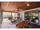 Charming screened-in patio with brick flooring, ceiling fan, wicker furniture, and a tranquil outdoor view at 1039 Union St, Clearwater, FL 33755