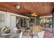 Inviting screened-in patio featuring wicker furniture, brick flooring, and a view of the well-maintained backyard at 1039 Union St, Clearwater, FL 33755
