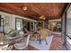 Inviting screened-in patio featuring a wood plank ceiling, comfortable wicker furniture, and views of the lush surroundings at 1039 Union St, Clearwater, FL 33755