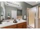 Bathroom featuring double sinks, a glass-enclosed shower, and a large mirror at 1051 Andrew Aviles Cir, Tampa, FL 33619