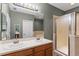 Bathroom featuring double sinks, a glass-enclosed shower, and a large mirror at 1051 Andrew Aviles Cir, Tampa, FL 33619