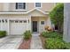 Inviting townhome with a single-car garage and well-manicured front yard featuring lush greenery at 1051 Andrew Aviles Cir, Tampa, FL 33619
