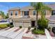 Exterior view showing two-story townhome featuring attached garage, landscaping, and neutral color scheme at 1051 Andrew Aviles Cir, Tampa, FL 33619