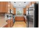 Well-lit kitchen featuring stainless steel appliances, wood cabinets, and a window overlooking the lush outdoors at 1051 Andrew Aviles Cir, Tampa, FL 33619